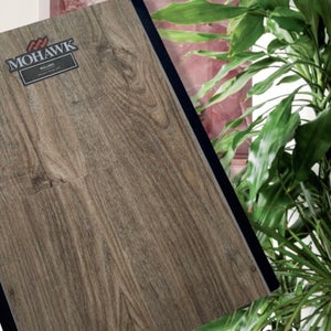 MOHAWK laminate flooring sample with indoor plants blurred background